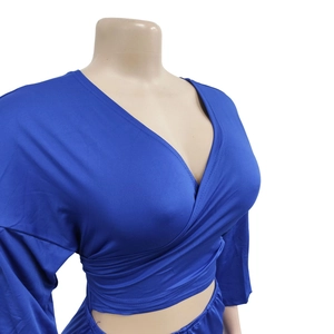 Detail of royal blue wrap V-neck top showing textured pleats and slim fit silhouette