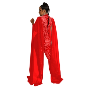 Macro detail of red rhinestone jumpsuit featuring sheer mesh cape and crystal patterns