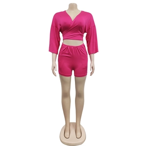 Detail view of fuchsia two-piece knit set featuring V-neck wrap top and high-waist shorts