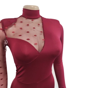Detail of burgundy jumpsuit featuring sheer mesh panels and elegant polka dot embroidery