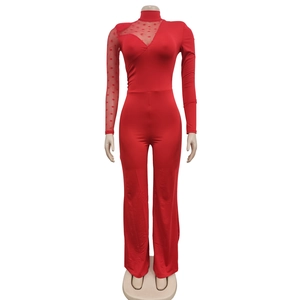 Detail of red mesh jumpsuit with polka dot sheer sleeves and asymmetric design
