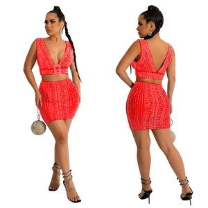 Détail d'un ensemble rouge deux pièces avec strass, haut col V et mini-jupe