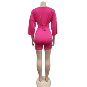 Detail of rose red romper with mid-sleeves and elastic waist tie on a mannequin