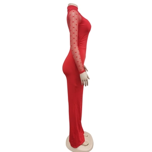 Detail of red mock neck jumpsuit featuring sheer polka dot mesh sleeves and slim fit design