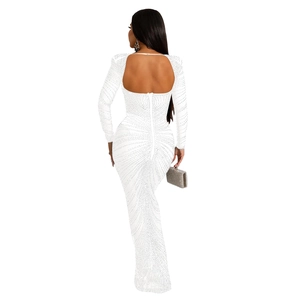 Détail d'une robe de soirée blanche dos nu avec strass brillants et manches longues
