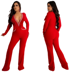 Detail of red slim fit jumpsuit showing V-neckline with feathers and rhinestone edging