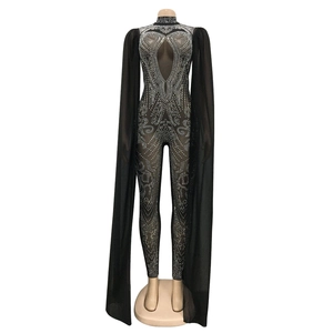 Detail of black jumpsuit with rhinestone patterns and dramatic floor-length cape sleeves