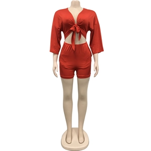 Detail of red two-piece set featuring long-sleeved tie-front top and high-waist shorts