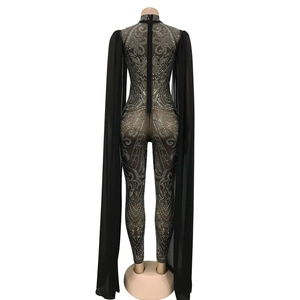 Detail of black mesh jumpsuit with sparkling silver rhinestones and long cape sleeves