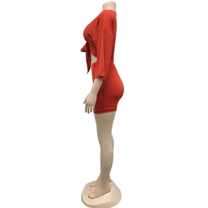 Detail of red two-piece set with crossover tie-front V-neck top and mini skirt
