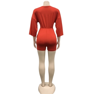 Rear view of a red short sleeve romper featuring a high waist elastic fit and knit fabric
