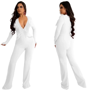 Detail of white V-neck jumpsuit featuring elegant feather trim and rhinestone accents