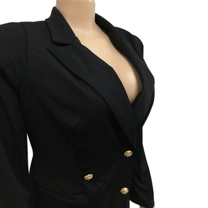 Detailed macro view of the gold embossed buttons and stitching on the black blazer