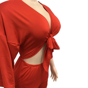 Detail view of red two-piece set featuring V-neck tie-front top and high-waist pants