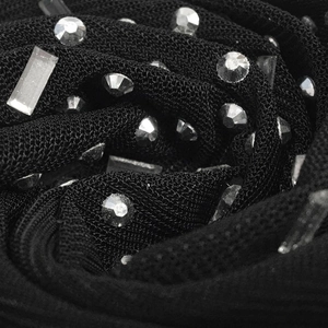 Détail macro des strass brillants sur le tissu en maille transparente noire d'une robe