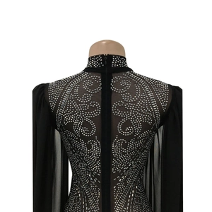 Detail of elegant black mesh jumpsuit featuring intricate silver rhinestone spiral patterns