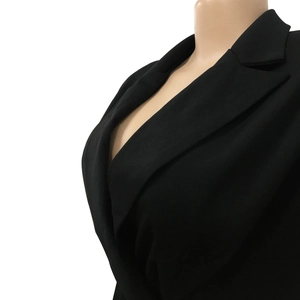 Detail of classic notched lapel and deep V-neck on a solid black blazer jacket