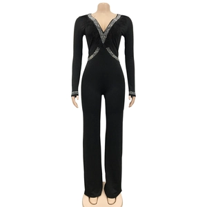 Detail of V-neck jumpsuit with shimmering rhinestones and black feather accents