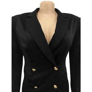 Detailed view of golden embossed metal buttons on a black double-breasted blazer
