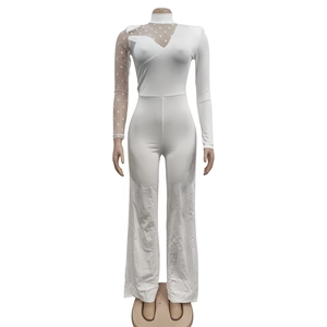 Detail of white jumpsuit featuring polka dot mesh sheer sleeve and wide leg cut