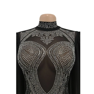 Close-up of sparkling rhinestone patterns on black sheer mesh jumpsuit top detail