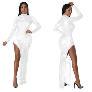 Macro detail of white long sleeve dress with rhinestones and high slit design