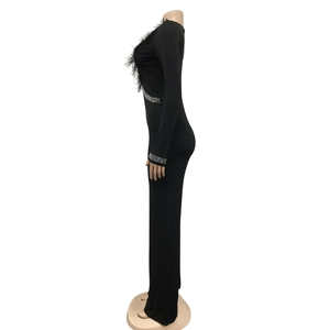 Detail of black long sleeve jumpsuit with feather neckline and rhinestone belt accents