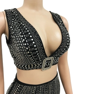 Détail du haut court noir sans manches avec décolleté en V et strass argentés brillants