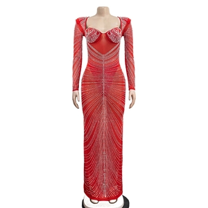 Détail d'une robe de soirée rouge en mesh ornée de strass argentés et de manches longues