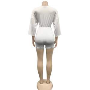 Back view of a white short jumpsuit featuring an elastic waist and mid-length sleeves