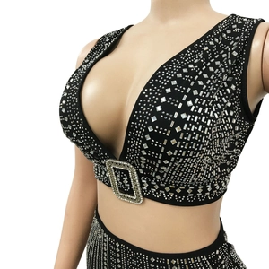 Détail du crop top noir à col en V avec strass argentés brillants et grande boucle décor