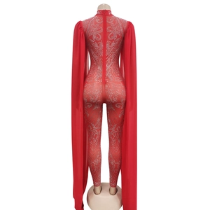 Detail of red rhinestone jumpsuit featuring sheer floor-length chiffon cape sleeves