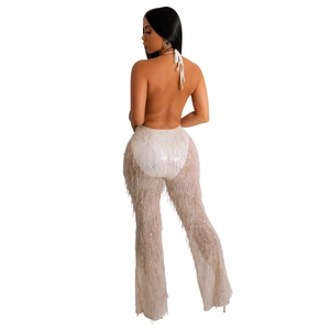 Détail du haut dos nu blanc avec pantalon large en maille à franges et paillettes