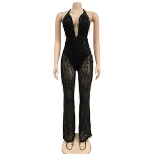 Détail de la combinaison noire à paillettes, col en V profond et pantalon en tulle ajouré