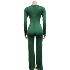 Close-up of a dark green jumpsuit featuring long sleeves with sparkling rhinestone cuffs