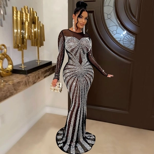 Detail of sheer black mesh evening gown featuring intricate silver rhinestone patterns