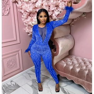Detail view of royal blue sequined jumpsuit with mesh deep V-neck and feather trim cuffs