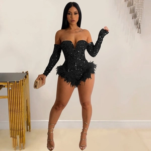 Detail of black sequined off-shoulder jumpsuit with feather trim on the leg cuffs