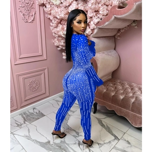Detail of sapphire blue rhinestone jumpsuit featuring elegant feather cuffs and v-neck