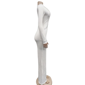 Detail of white long sleeve jumpsuit featuring sparkling rhinestone fringe and V-neckline