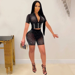 Close-up of black mesh fabric with silver rhinestone details on women's two-piece set