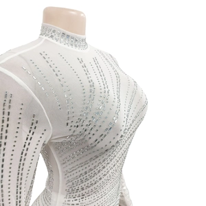 Detailed close-up of white mesh fabric with shimmering silver rhinestones and high collar