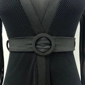 Close-up of black elastic wide waist belt with a large fabric-wrapped round buckle detail
