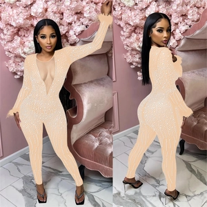 Detail of sequined mesh jumpsuit featuring feather cuffs and a deep V-neckline for parties