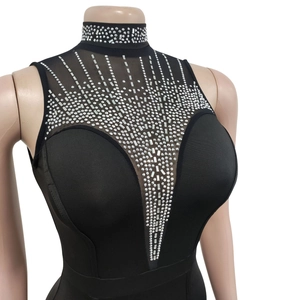 Détail du col en V en mesh transparent avec strass argentés sur une robe noire sans manches