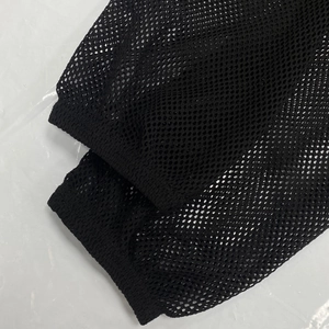 Detail of sheer black fishnet mesh sleeve with elastic ribbed cuff for women