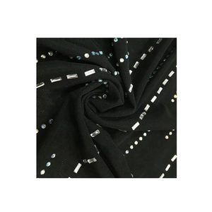 Dettaglio macro del tessuto a rete nero con strass scintillanti per abiti da sera