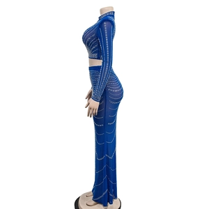 Detailansicht aus blauem Mesh-Stoff mit weißen Strasssteinen am langärmeligen Maxikleid