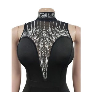 Détails des strass et du patchwork en mesh sur une robe noire sans manches