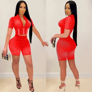 Detail of red mesh crop top and shorts set with silver rhinestones and deep V-neckline